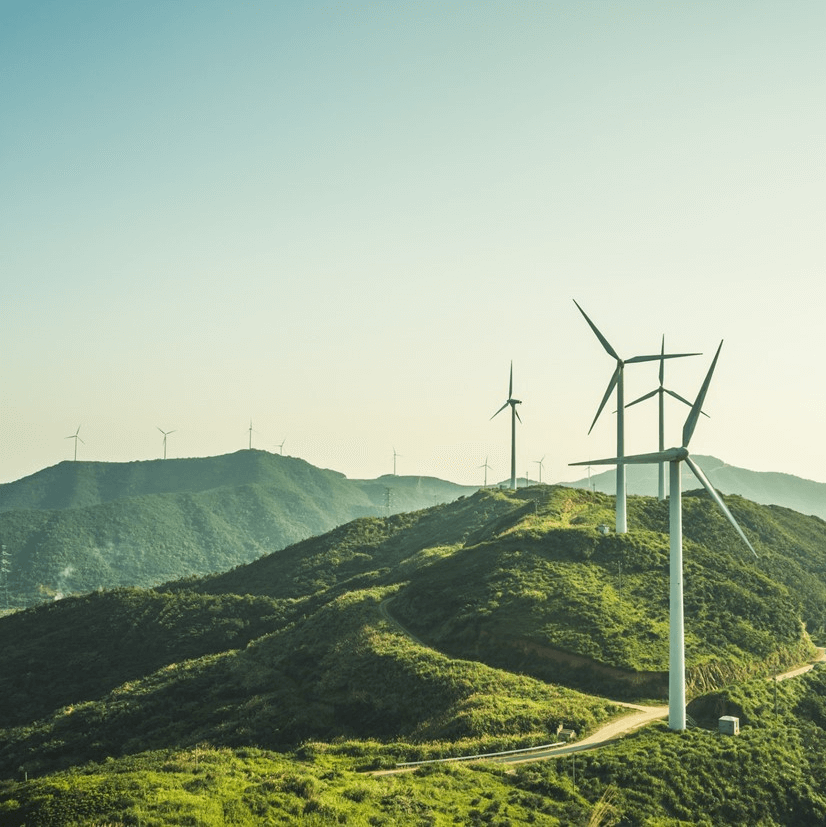 Wind turbines over lush green hills